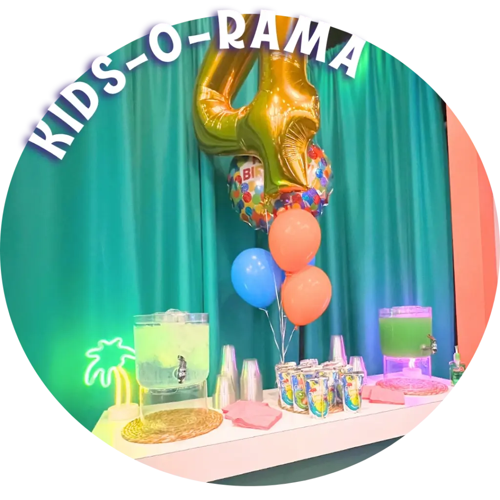 KIDS-O-RAMA birthday party table with a neon palm tree, drink dispensers, and a gold number four balloon